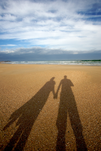 Shadow of couple on a beach holding hands. Shot with a Canon 1ds II camera.