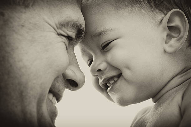 Black and white image of a man holding a baby