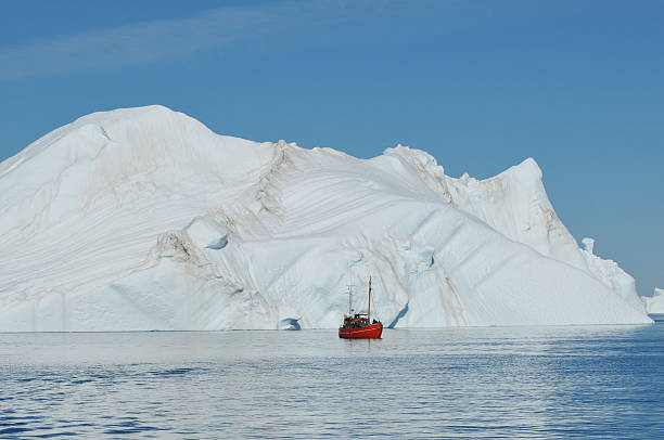 istock Small boat in front of big iceberg 155259278
