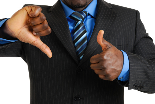 This is an image of a business man showing thumbs up and thumbs down.