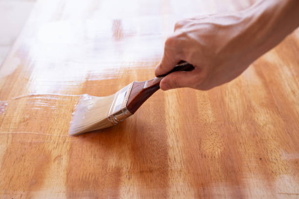 нанесите чистую морилку на стол кистью - wood coating floor house стоковые фото и изображения