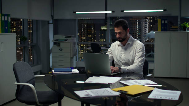 istock Successful entrepreneur work on laptop with night cityscape view outside panoramic windows. 1552602228