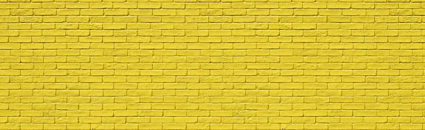 istock yellow brick wall, panorama design in spring. Stones for a modern concept background with copy space 1552603271