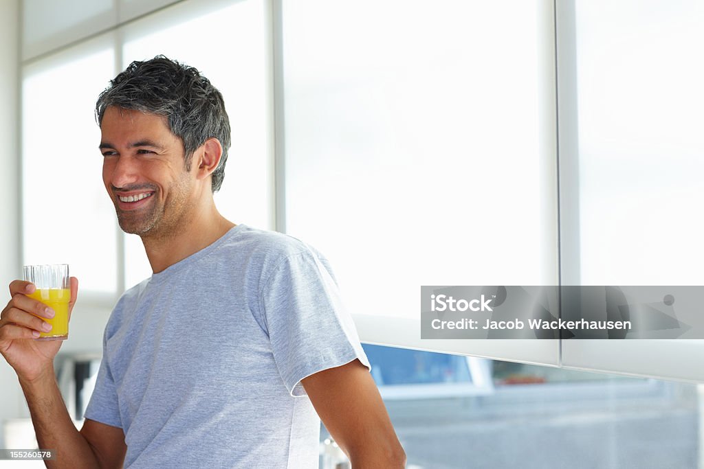 Mature man holding a glass of juice Horizontal Stock Photo