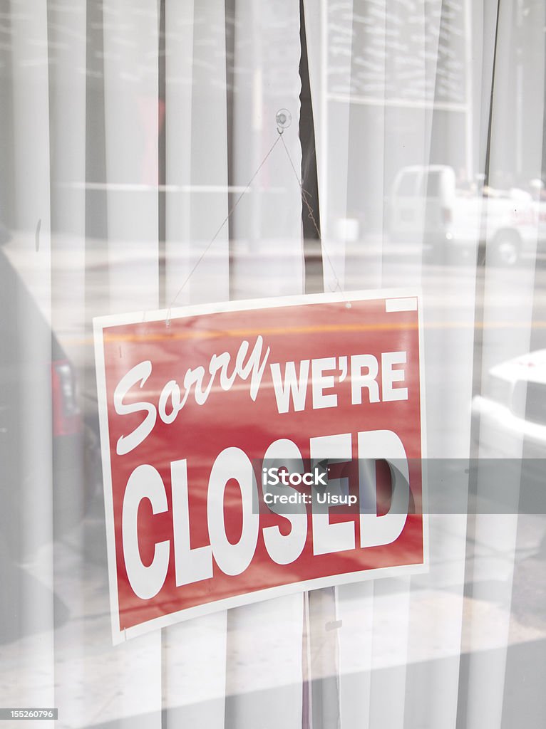 Sorry were closed sign surrounded by reflections of the street A sorry were closed sign surronunded by reflections of the street behind. Closed Sign Stock Photo