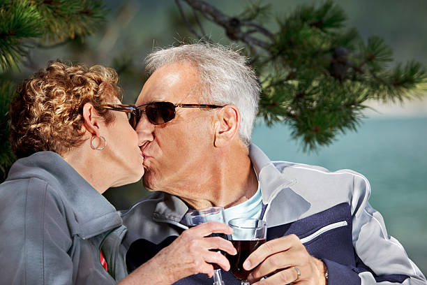 Seniors kissing by the lake stock photo