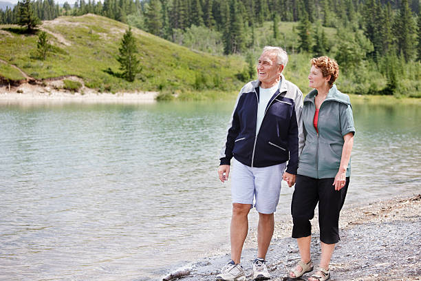 istock Senior couple walking by the lake 155261337