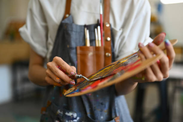 istock Unrecognizable male artist mixing oiled paints with spatula on a palette. 1552629157