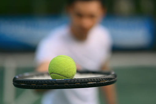 Close up view of male tennis player holding racket and ball. Sport, training, competition and active life concept.