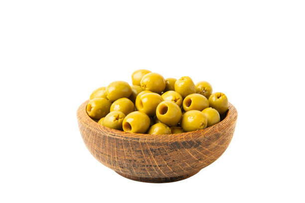 istock Delicious green olives isolated on white background. Olive and olive tree branches on a white table. Delicacy. 1552656579