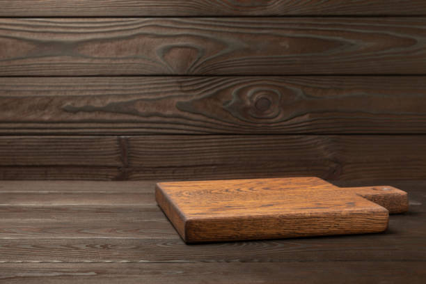istock Cutting board on a textured  kitchen table. Menu food card or recipes background concept.MOCKUP. Design. Place for text, copy space. The concept of food and cooking. 1552661828