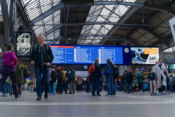 Swiss train station with passengers walking at main hall at Swiss town. Train passengers at main hall of railway main station with departure board in the background at City of Zürich on a sunny spring day. Photo taken May 22nd, 2023, Zurich, Switzerland. zurich train station stock pictures, royalty-free photos & images