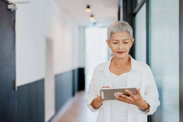 istock Asian senior businesswoman using digital tablet in modern office 1552671313