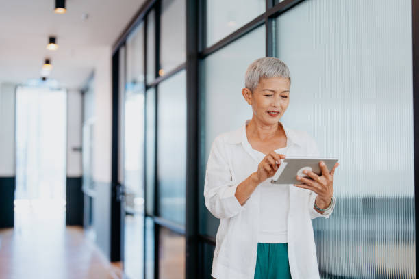 istock Asian senior businesswoman using digital tablet in modern office 1552671742