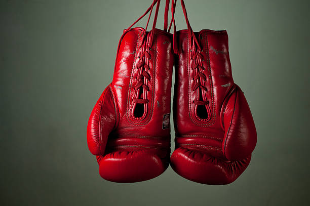 istock Boxing gloves hanging from laces on a grey background. 155268144