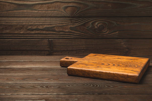 istock Cutting board on a textured  kitchen table. Menu food card or recipes background concept.MOCKUP. Design. Place for text, copy space. The concept of food and cooking. 1552683363