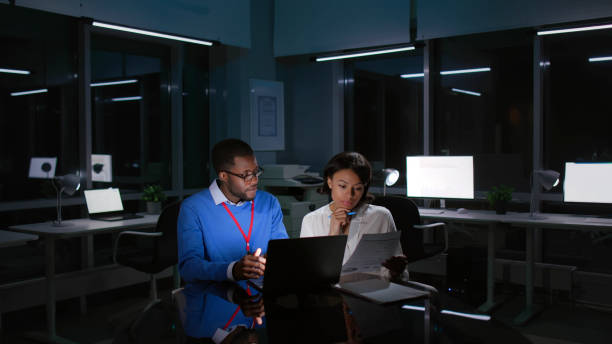 istock Multiethnic colleagues working late on laptop in dark office 1552687739