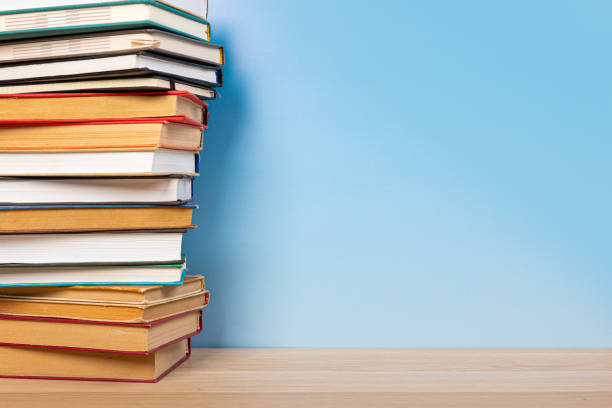 istock Composition with vintage old hardback books, diary on wooden table and blue background. Books stacking. Back to school. Copy Space. Education background. 1552694462