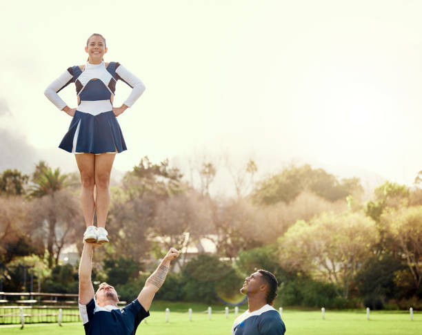 cheerleader, membres de l’équipe de plein air et groupe d’athlètes avec conditionnement physique, uniforme et routine de cheerleading avec équilibre. exercice, compétition et acclamations, collaboration et plaisir avec l’événement sportif sur l - sports uniform blue team event sports activity photos et images de collection