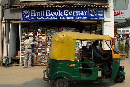 The facade of a book store behind a Tuk Tuk in the old part of New Delhi, India