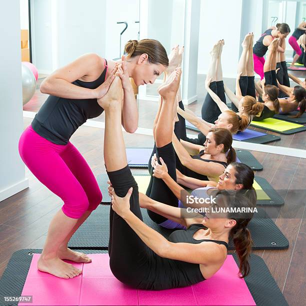 Aerobics Pilates Personal Trainer Helping Women Group Stock Photo - Download Image Now