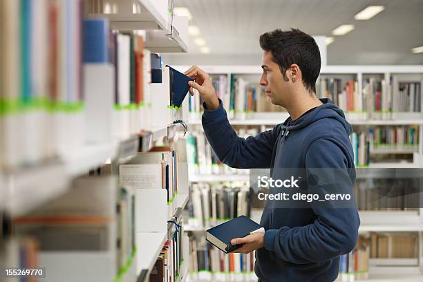 Uomo Scegliendo Il Libro In Biblioteca - Fotografie stock e altre immagini di 20-24 anni - 20-24 anni, Abbigliamento casual, Accessibilità