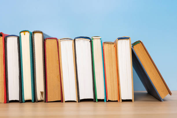 istock Composition with vintage old hardback books, diary on wooden table and blue background. Books stacking. Back to school. Copy Space. Education background. 1552699987