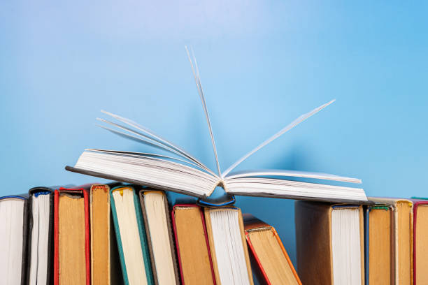 istock Composition with vintage old hardback books, diary on blue background. Books stacking. Back to school. Copy Space. Education background. 1552699990