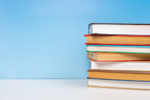 istock Composition with vintage old hardback books, diary on wooden table and blue background. Books stacking. Back to school. Copy Space. Education background. 1552705362