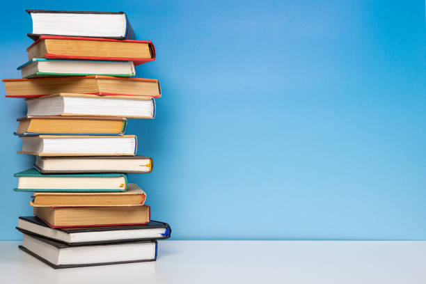 istock Composition with vintage old hardback books, diary on wooden table and blue background. Books stacking. Back to school. Copy Space. Education background. 1552705870