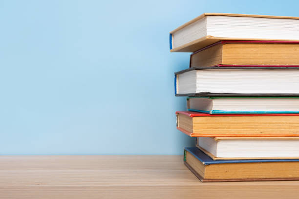 istock Composition with vintage old hardback books, diary on wooden table and blue background. Books stacking. Back to school. Copy Space. Education background. 1552705879