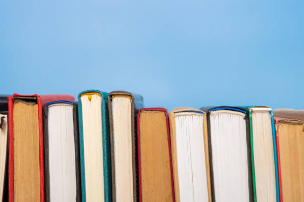 istock Composition with vintage old hardback books, diary on blue background. Books stacking. Back to school. Copy Space. Education background. 1552705904