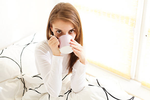 istock girl drinking coffee or tea in bed 155271467