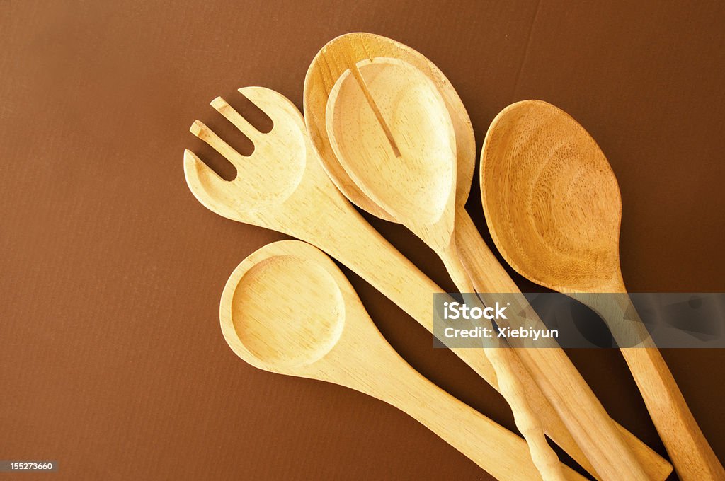 Kitchen Utensils Wooden kitchen utensils lying on brown background. Brown Stock Photo