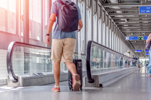 View Of Unrecognizable Man Walking With Suitcase In Airport Terminal