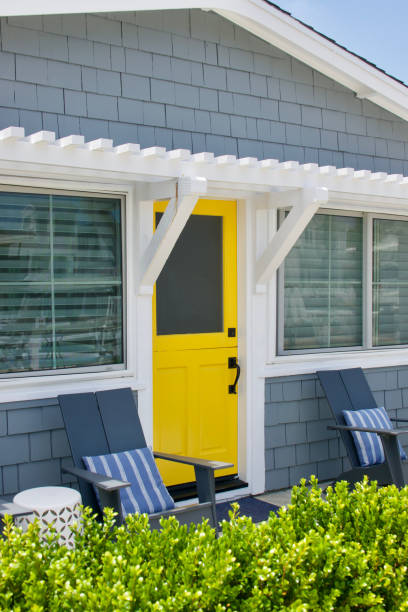 istock Cute beach cottage with lemon yellow front door 1552743380