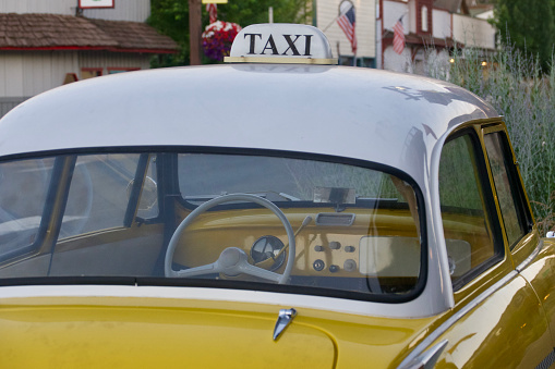 Angola, United States – December 01, 2022: A yellow taxi cab parked on the road