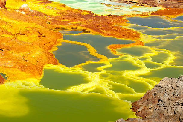 Inside the explosion crater of Dallol volcano, Danakil Depression, Ethiopia The volcanic explosion crater of Dallol in the Danakil Depresseion in Nothern Ethiopia. The Dallol crater was formed during a phreatic eruption in 1926. This crater is known as the lowest subaerial vulcanic vents in the world. The surreal colours are caused by green acid ponds and iron oxides and sulfur. danakil depression stock pictures, royalty-free photos & images