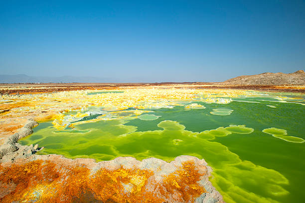 Inside the explosion crater of Dallol volcano, Danakil Depression, Ethiopia The volcanic explosion crater of Dallol in the Danakil Depresseion in Nothern Ethiopia. The Dallol crater was formed during a phreatic eruption in 1926. This crater is known as the lowest subaerial vulcanic vents in the world. The surreal colours are caused by green acid ponds and iron oxides and sulfur. dallol ethiopia stock pictures, royalty-free photos & images