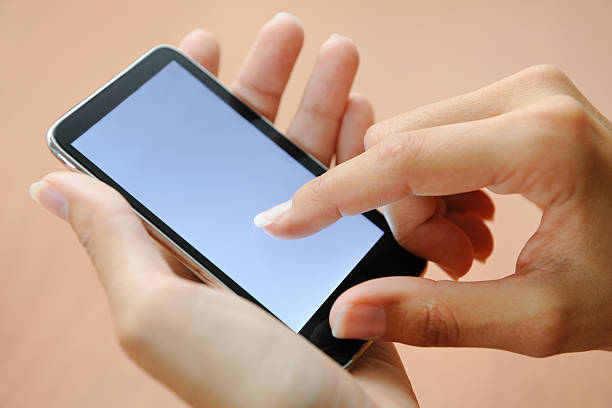 Finger pointing on a Smart Phone (XXXL) Natural manicured finger pointing on a Smart Phone. Nikon D3X. Converted from RAW. smart card stock pictures, royalty-free photos & images