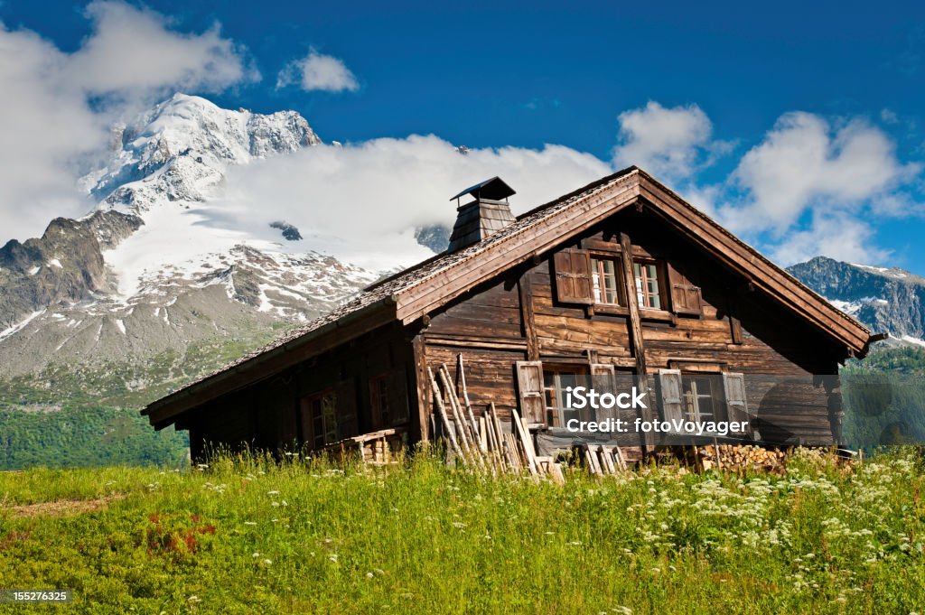 Tradycyjnej drewnianej Alpine chalet lato Łąka snowy mountains - Zbiór zdjęć royalty-free (Chata w górach)