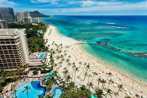 Aereal photo of Waikiki beach with view of Diamond Head mountain in the distance.