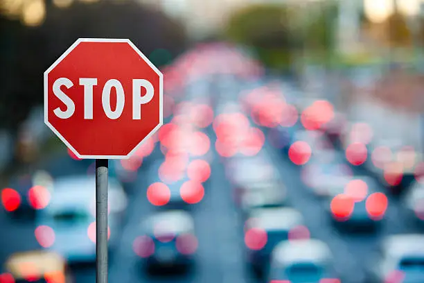 Photo of Stop sign with traffic and cars at rush hour