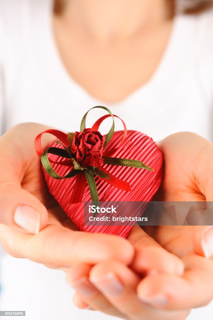 Giovane donna con un regalo rosso a forma di cuore - Foto stock royalty-free di Adulto