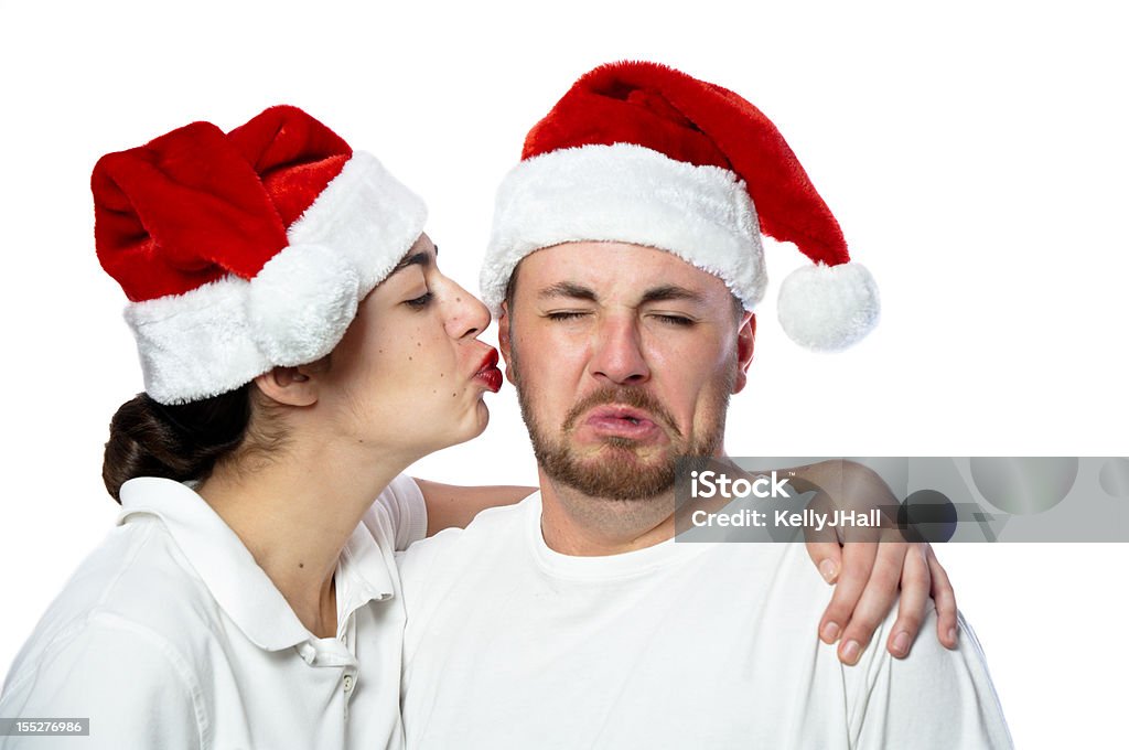 Unhappy young man getting kissed on cheek A stock photo of an unhappy young man getting a kiss on the cheek from a woman Adult Stock Photo