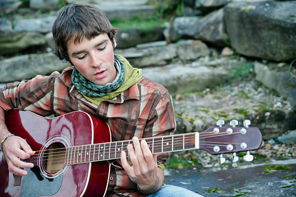 istock Young man singing and playing acoustic guitar. 155276993