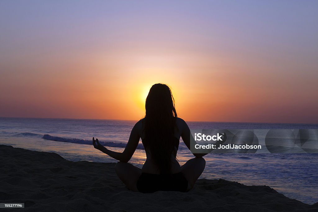 Mujer de silueta meditación al atardecer - Foto de stock de Actividades y técnicas de relajación libre de derechos