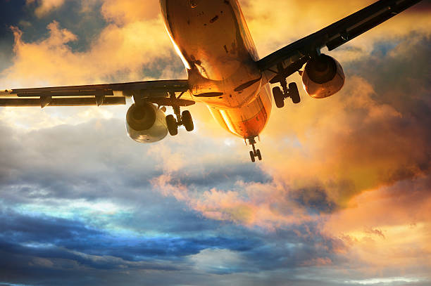 aero atterra la sera - wing airplane window sunset foto e immagini stock