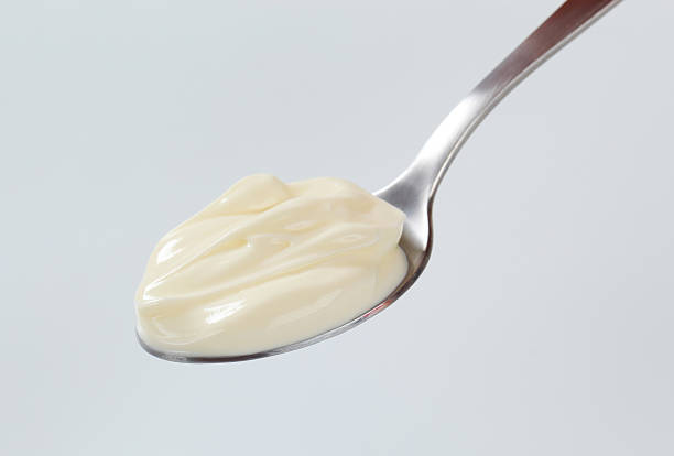 A teaspoon with a dollop of thick cream on it Spoon of smooth cream custard stock pictures, royalty-free photos & images