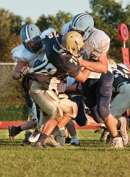 football players blocking an opponent stock photo